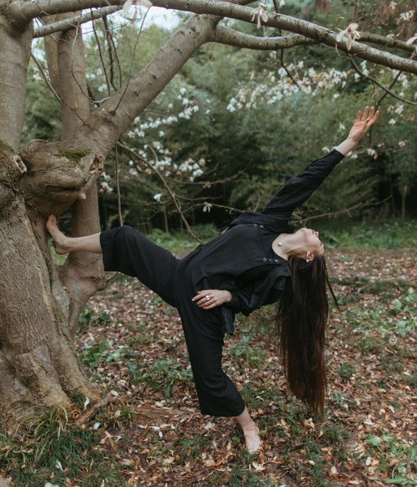 Woman performing a graceful yoga pose in a calm environment.